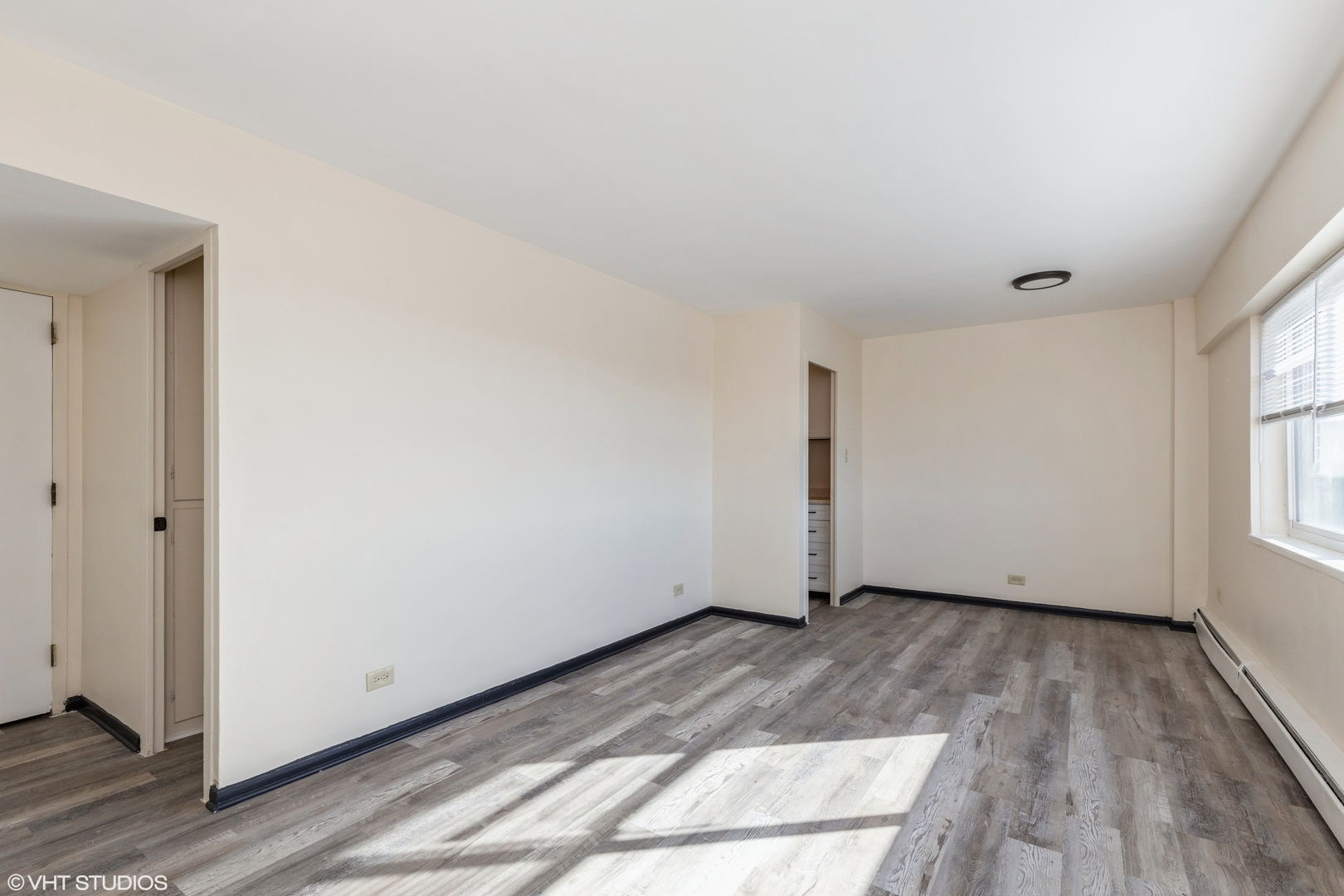 1400 Chicago Avenue, Unit 802 Evanston, IL 60201 - Photo 2 of 9 an empty room with wooden floor and windows