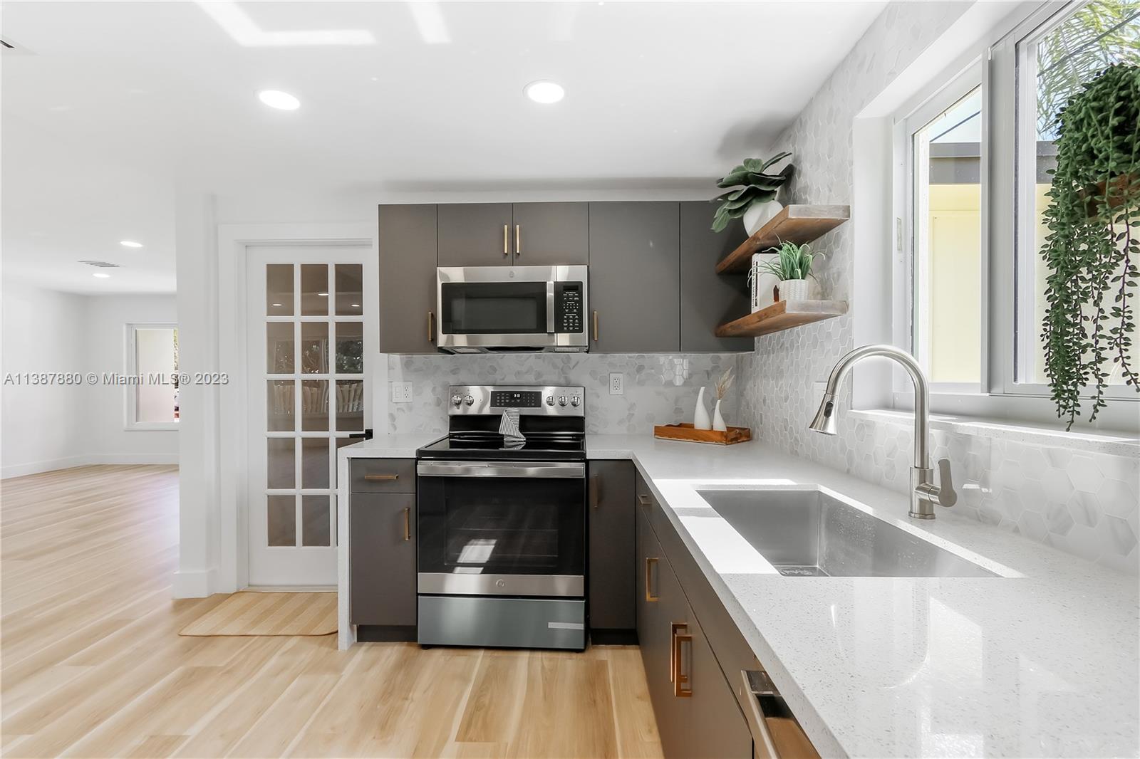 269 Northwest 12th Street Boca Raton, FL 33432 - Photo 8 of 18 a kitchen with kitchen island a sink appliances and cabinets