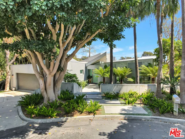 a front view of a house with a tree s