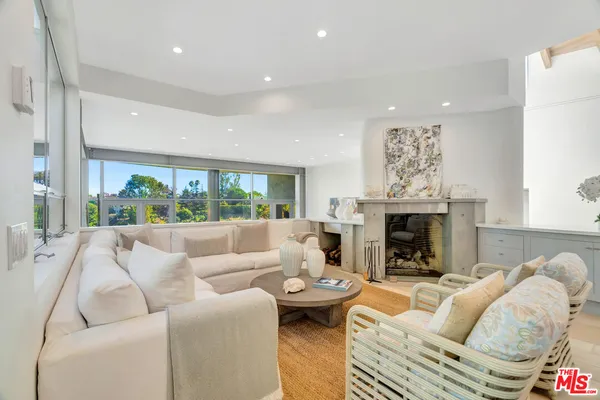a living room with furniture fireplace and a large window