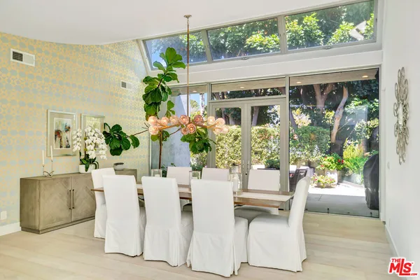 a dining room with furniture potted plants and wooden floor