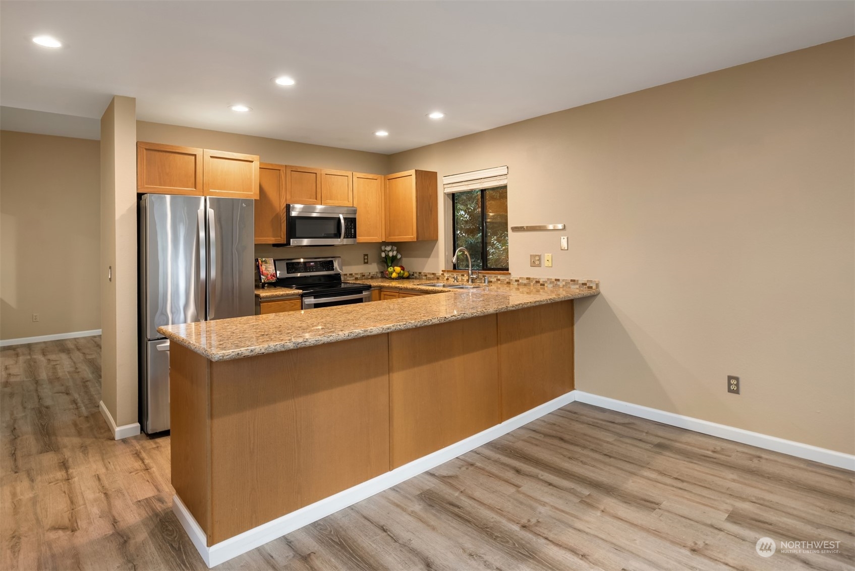9009 Avondale Road Northeast, Unit R 235 Redmond, WA 98052 - Photo 11 of 24 a kitchen with stainless steel appliances granite countertop a stove a refrigerator a sink and a oven with wooden floor