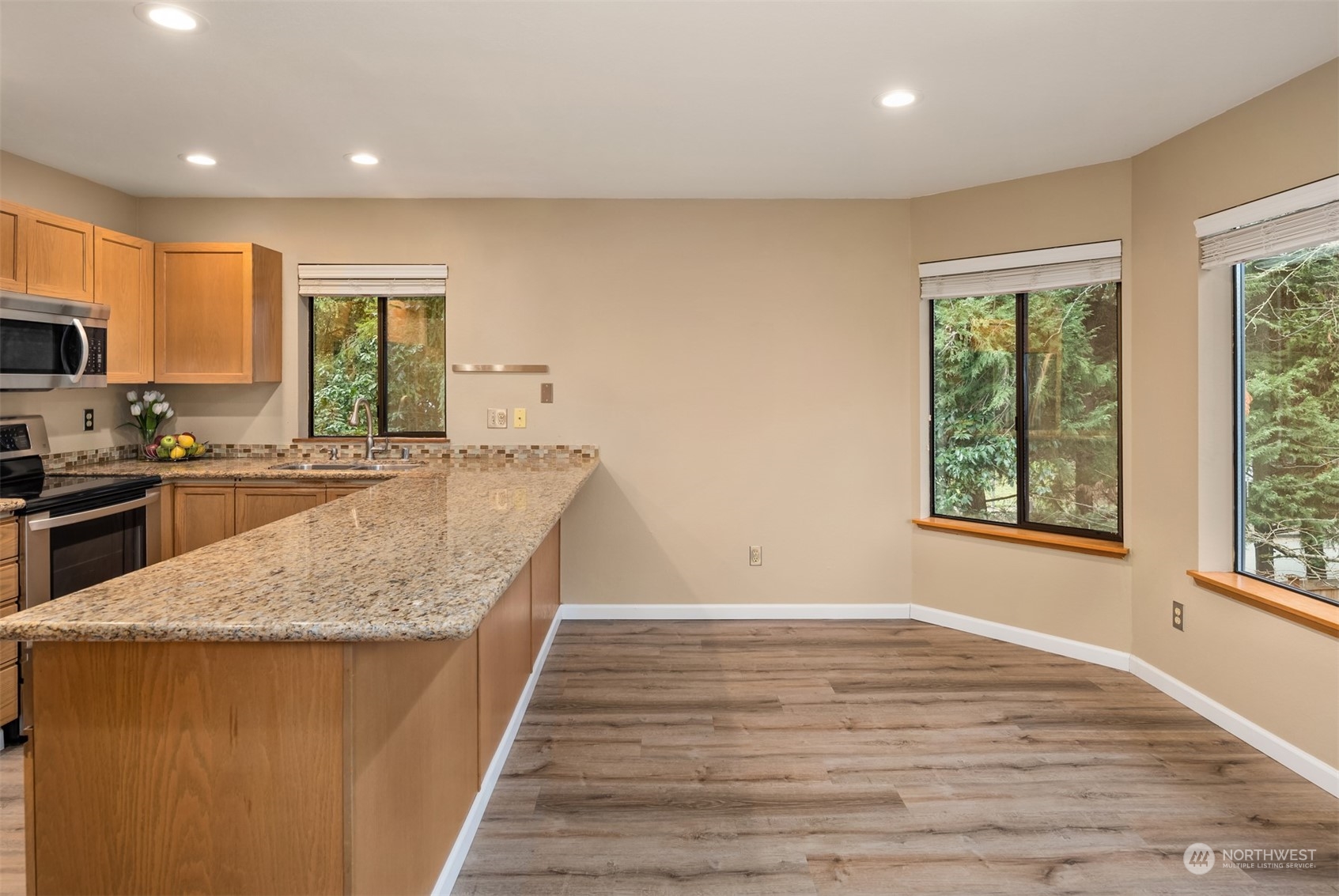 9009 Avondale Road Northeast, Unit R 235 Redmond, WA 98052 - Photo 13 of 24 a large kitchen with granite countertop a large counter top stainless steel appliances a sink and cabinets