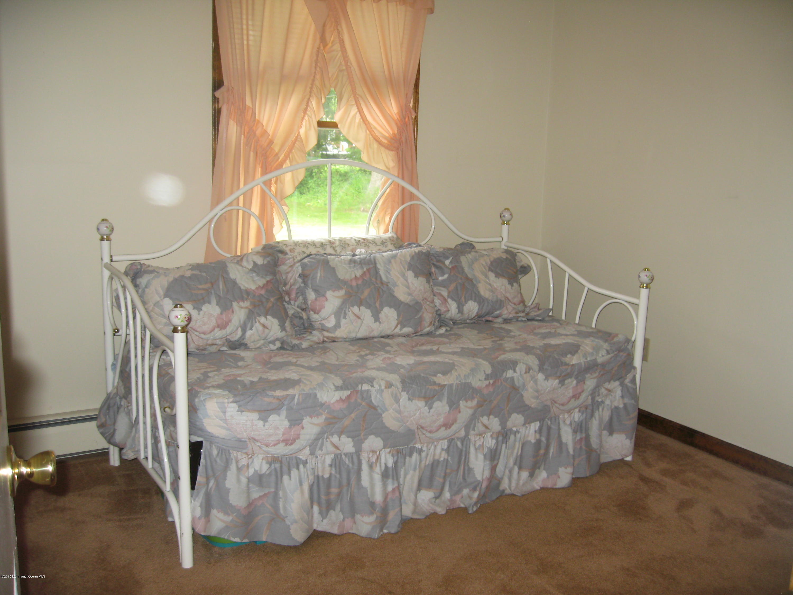 428 Oak Tree Road Freehold, NJ 07728 - Photo 11 of 18 a bed sitting in a room next to a window