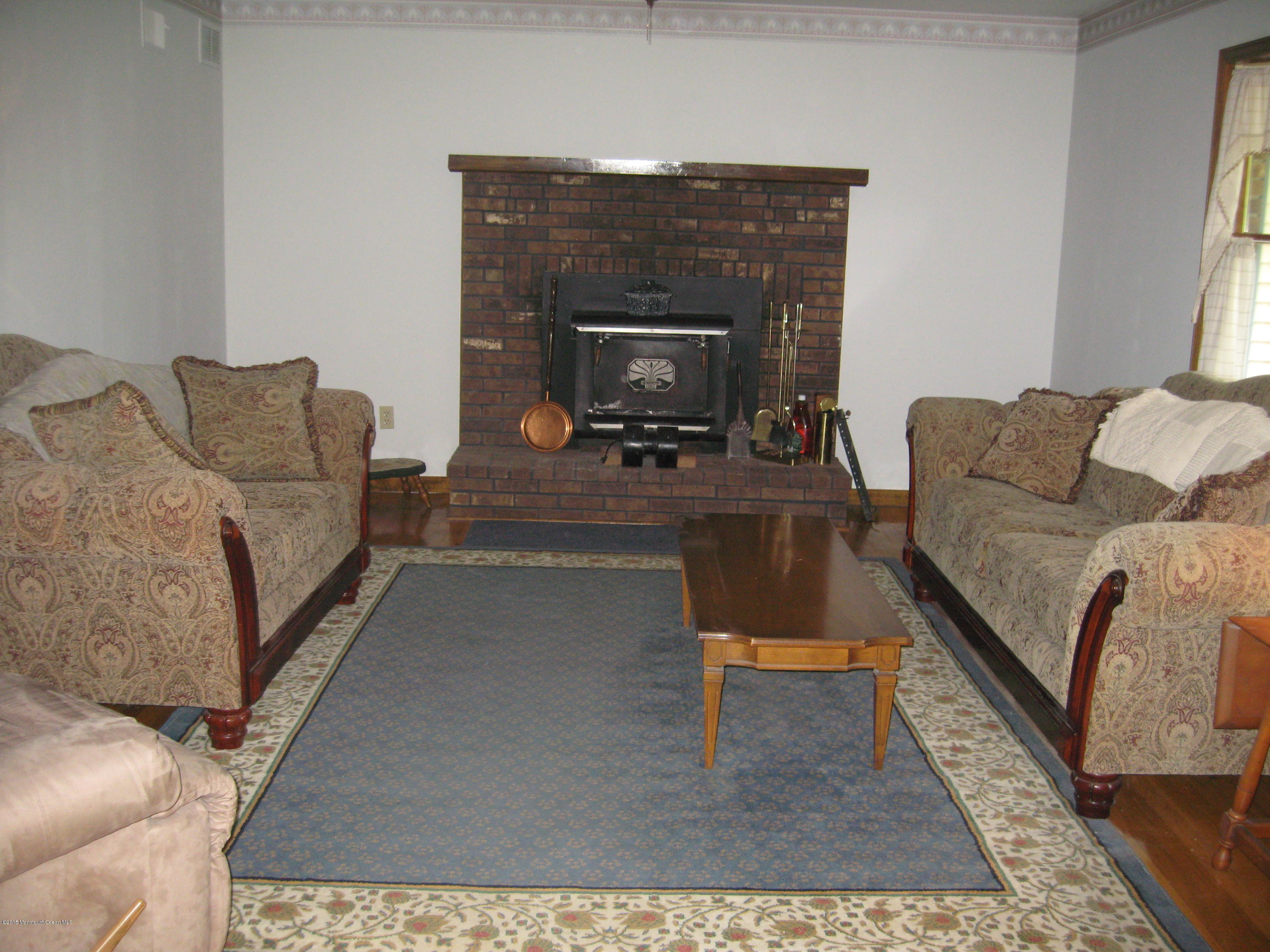 428 Oak Tree Road Freehold, NJ 07728 - Photo 12 of 18 a living room with furniture and a fireplace