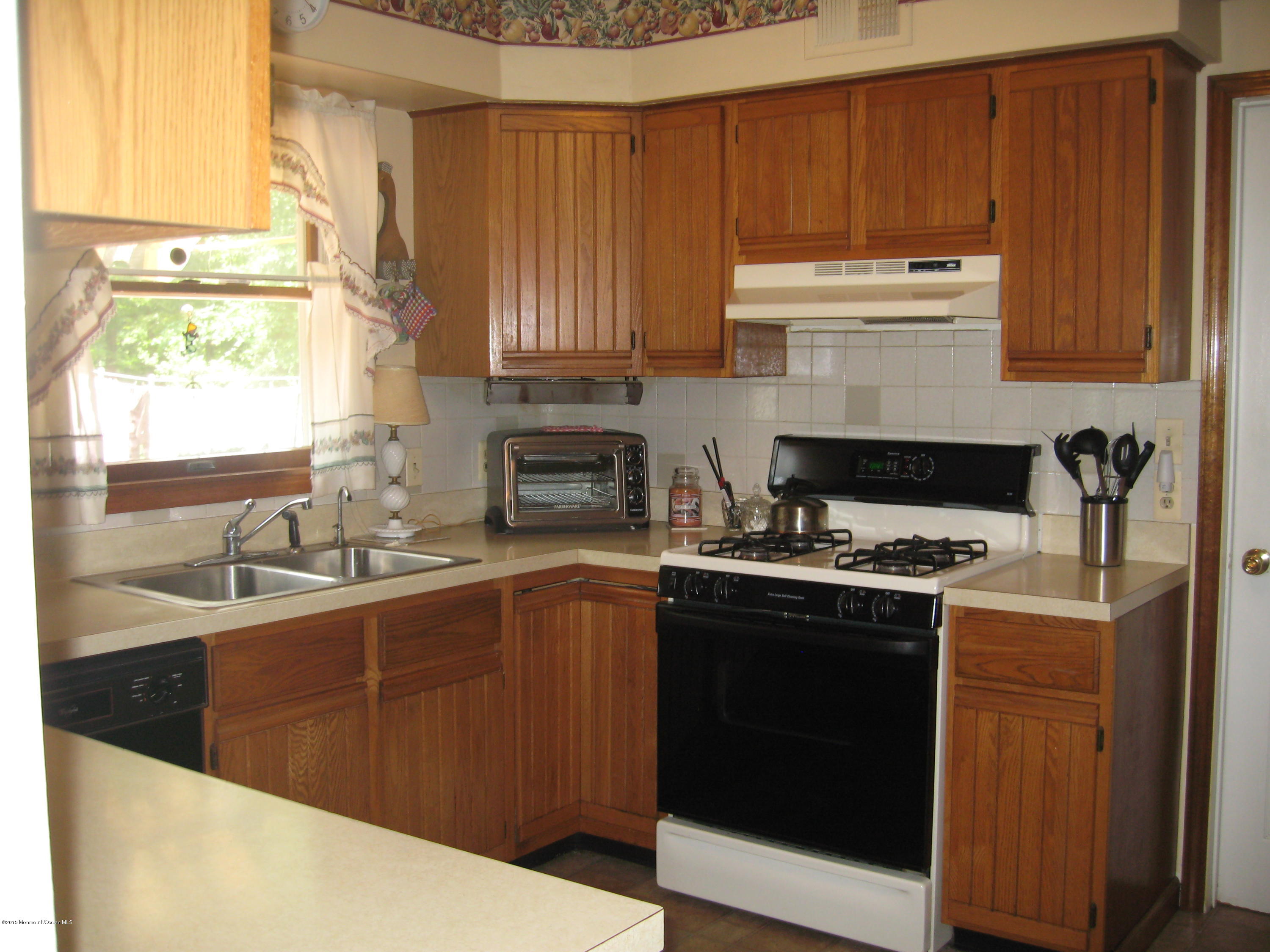428 Oak Tree Road Freehold, NJ 07728 - Photo 6 of 18 a kitchen with a sink stove and cabinets