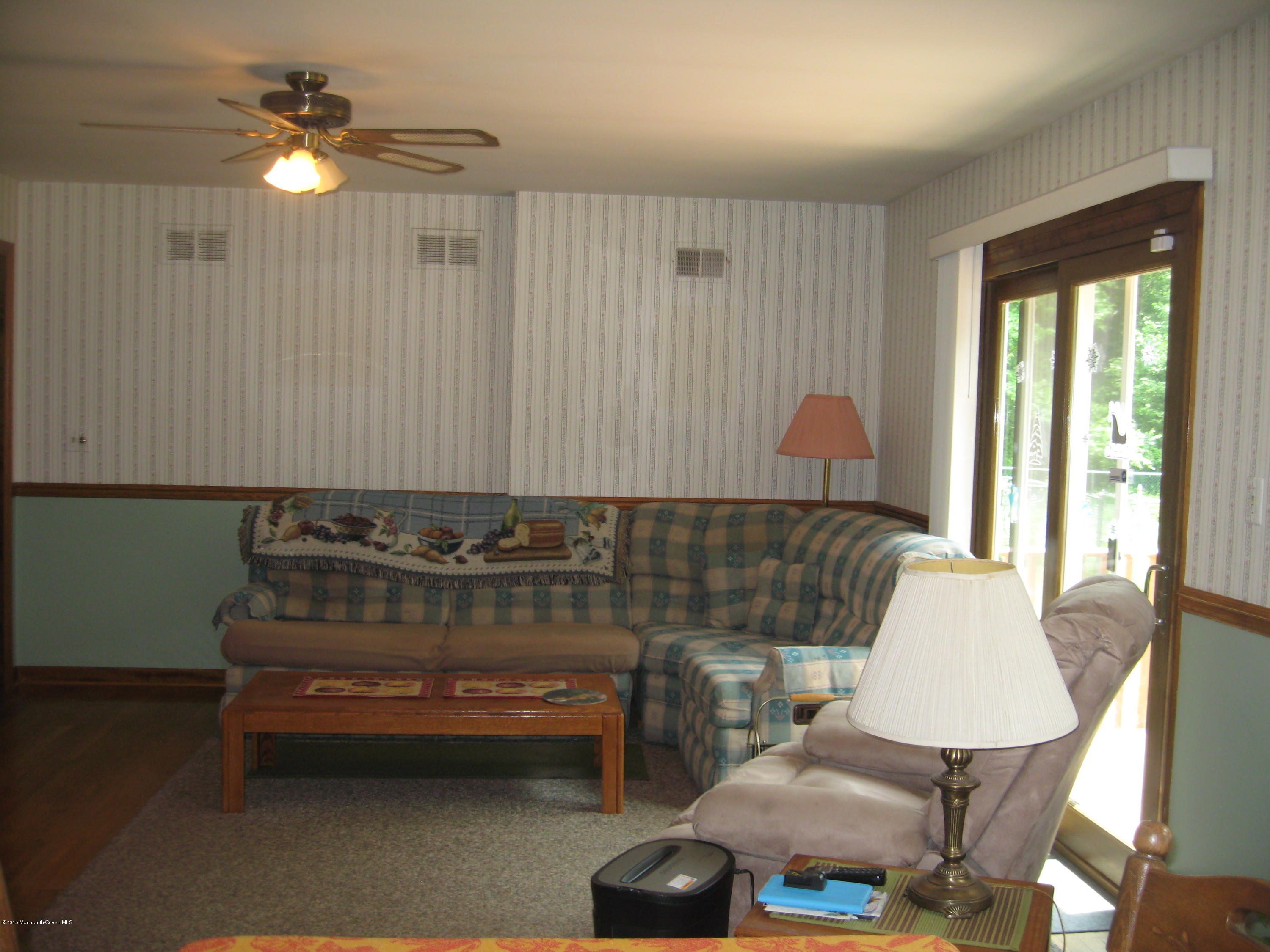 428 Oak Tree Road Freehold, NJ 07728 - Photo 8 of 18 a living room with a couch and a chandelier