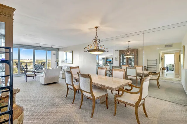 a kitchen with stainless steel appliances kitchen island granite countertop a sink dishwasher stove top oven a dining table and chairs with wooden floor