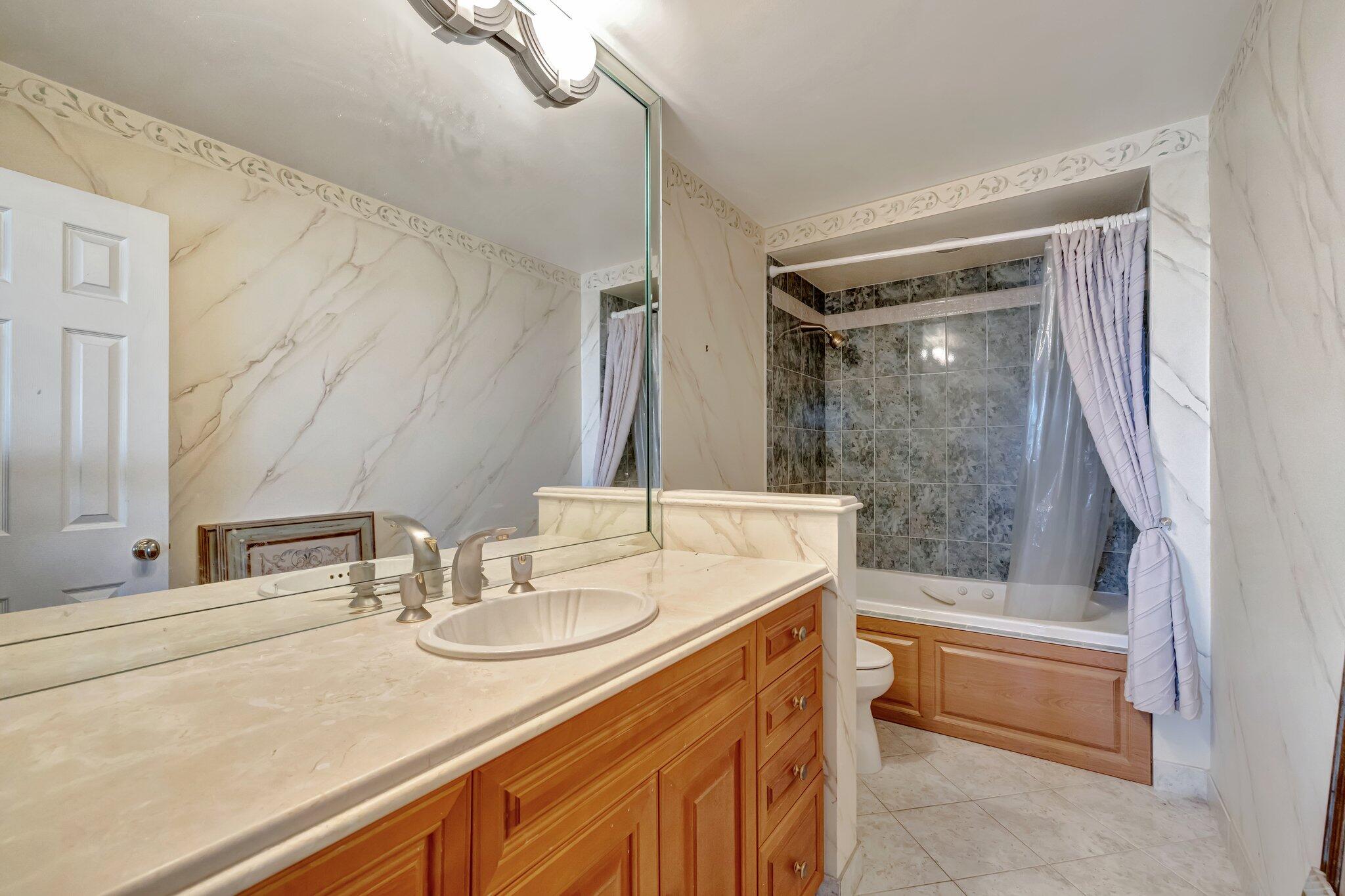 521 North Riverside Drive, Unit 1207 Pompano Beach, FL 33062 - Photo 34 of 50 a bathroom with a granite countertop sink mirror and a bath tub