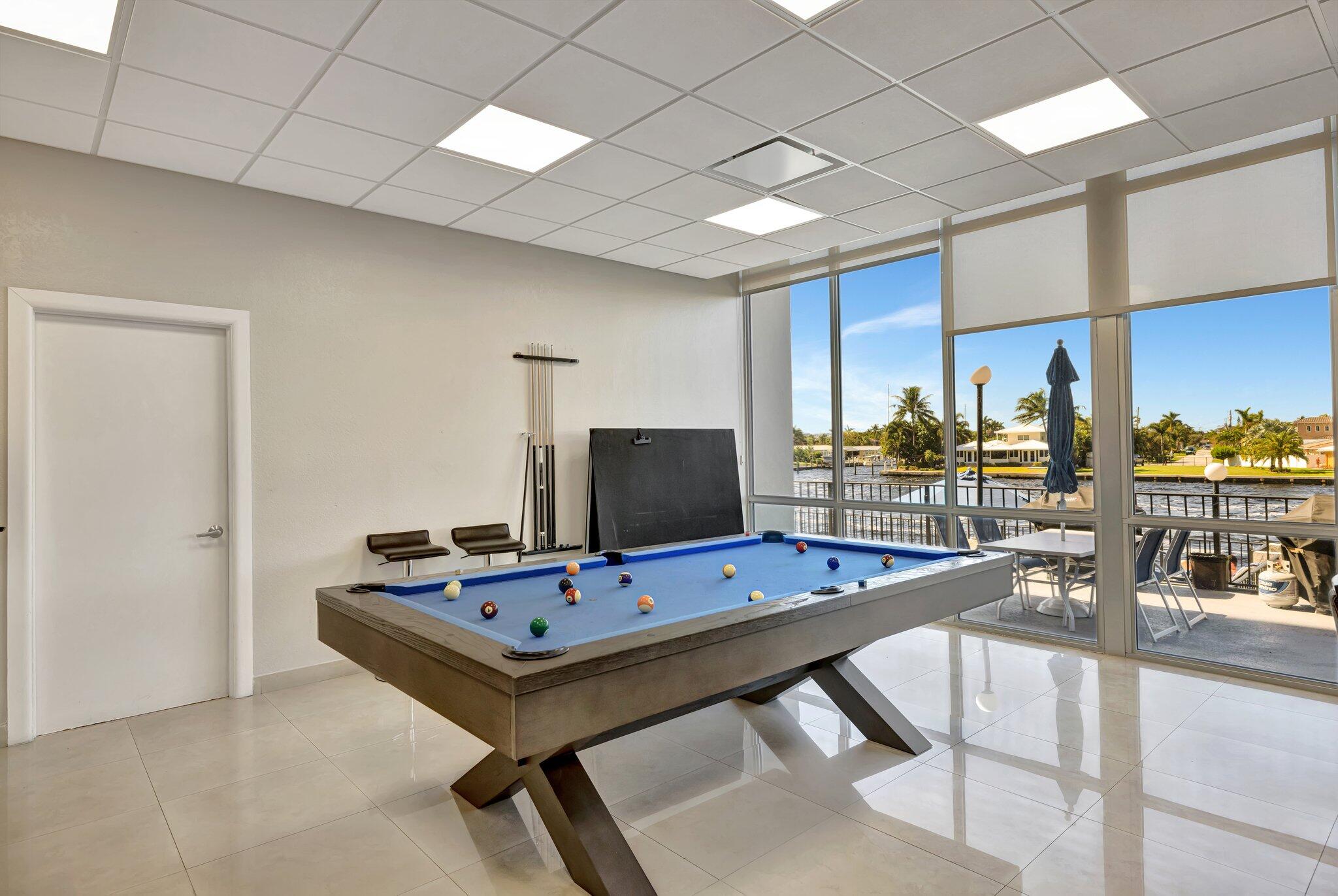 521 North Riverside Drive, Unit 1207 Pompano Beach, FL 33062 - Photo 39 of 50 a room with table chairs and flat screen tv