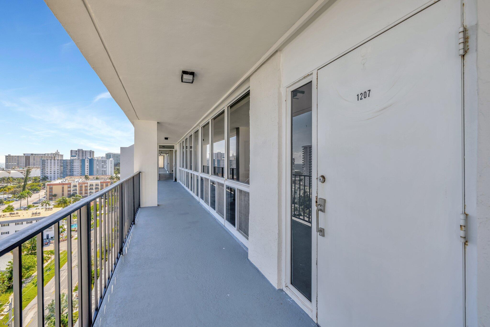 521 North Riverside Drive, Unit 1207 Pompano Beach, FL 33062 - Photo 9 of 50 a view of staircase with lots of frames on wall and a large window