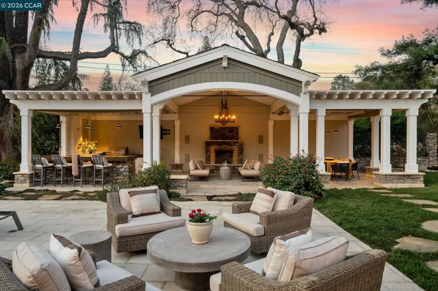a living room with furniture a fireplace and a chandelier