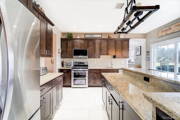a kitchen with stainless steel appliances granite countertop a sink stove and refrigerator