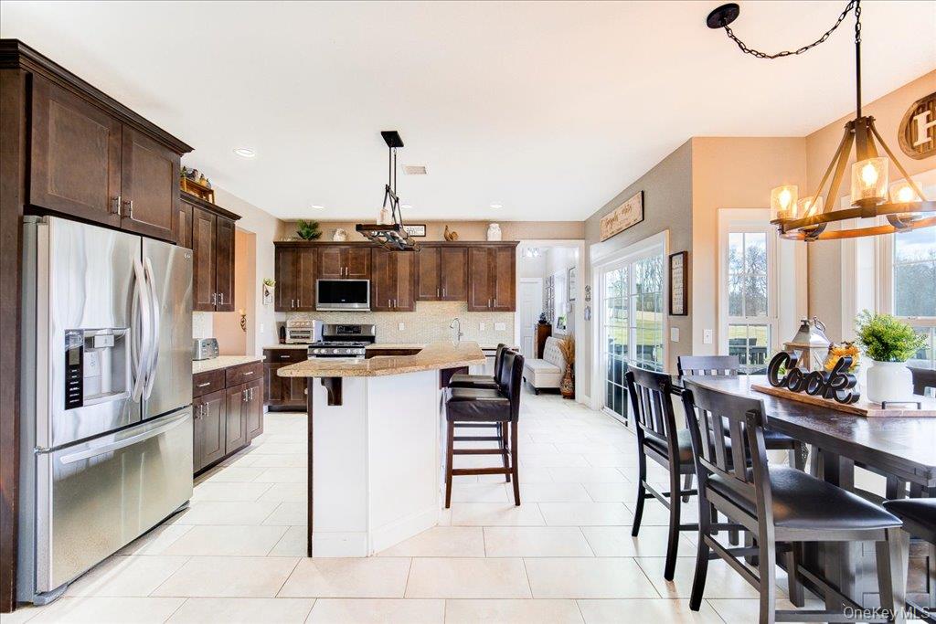 77 Houston Road Goshen, NY 10924 - Photo 17 of 46 a kitchen with stainless steel appliances kitchen island granite countertop a table chairs and a refrigerator