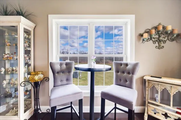 a view of a dining room with furniture a rug and wooden floor