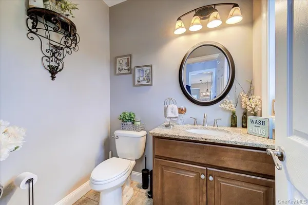 a bathroom with a toilet sink vanity and mirror