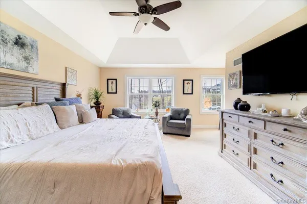 a spacious bedroom with a bed a couch and a flat screen tv