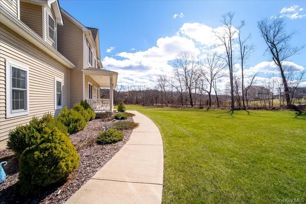 a view of a fountain in front of a house with a big yard