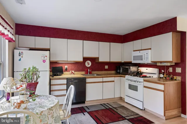 a kitchen with stainless steel appliances granite countertop a stove top oven a sink dishwasher and cabinets with wooden floor