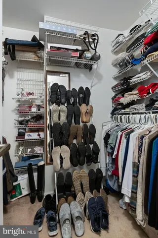 a view of walk in closet with clothes and shoes