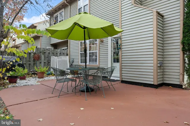 a view of a patio with a table and chairs under an umbrella