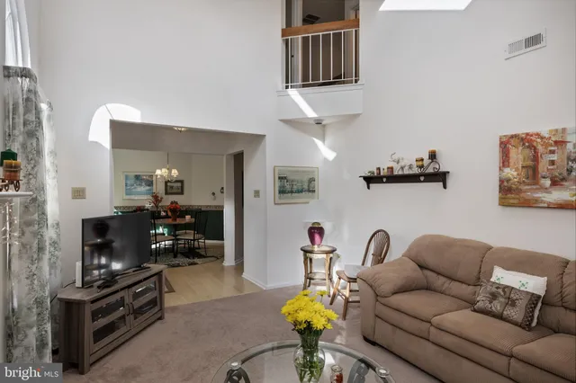 a living room with furniture a flat screen tv and kitchen view