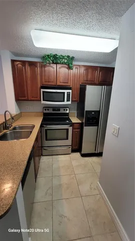 a kitchen with wooden cabinets and stainless steel appliances