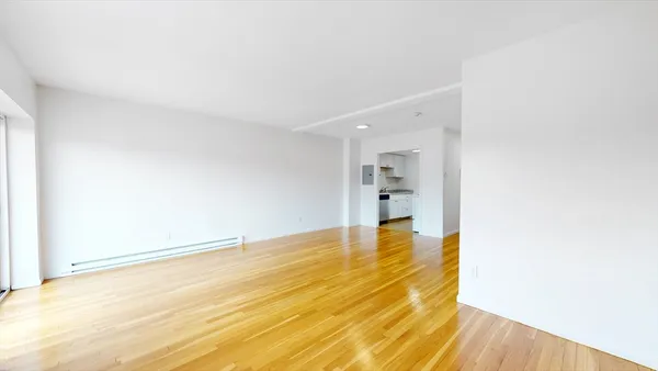 a view of empty room with wooden floor