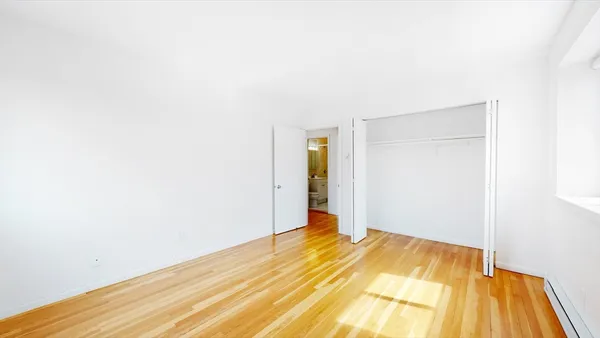 a view of a room with wooden floor and a bathroom