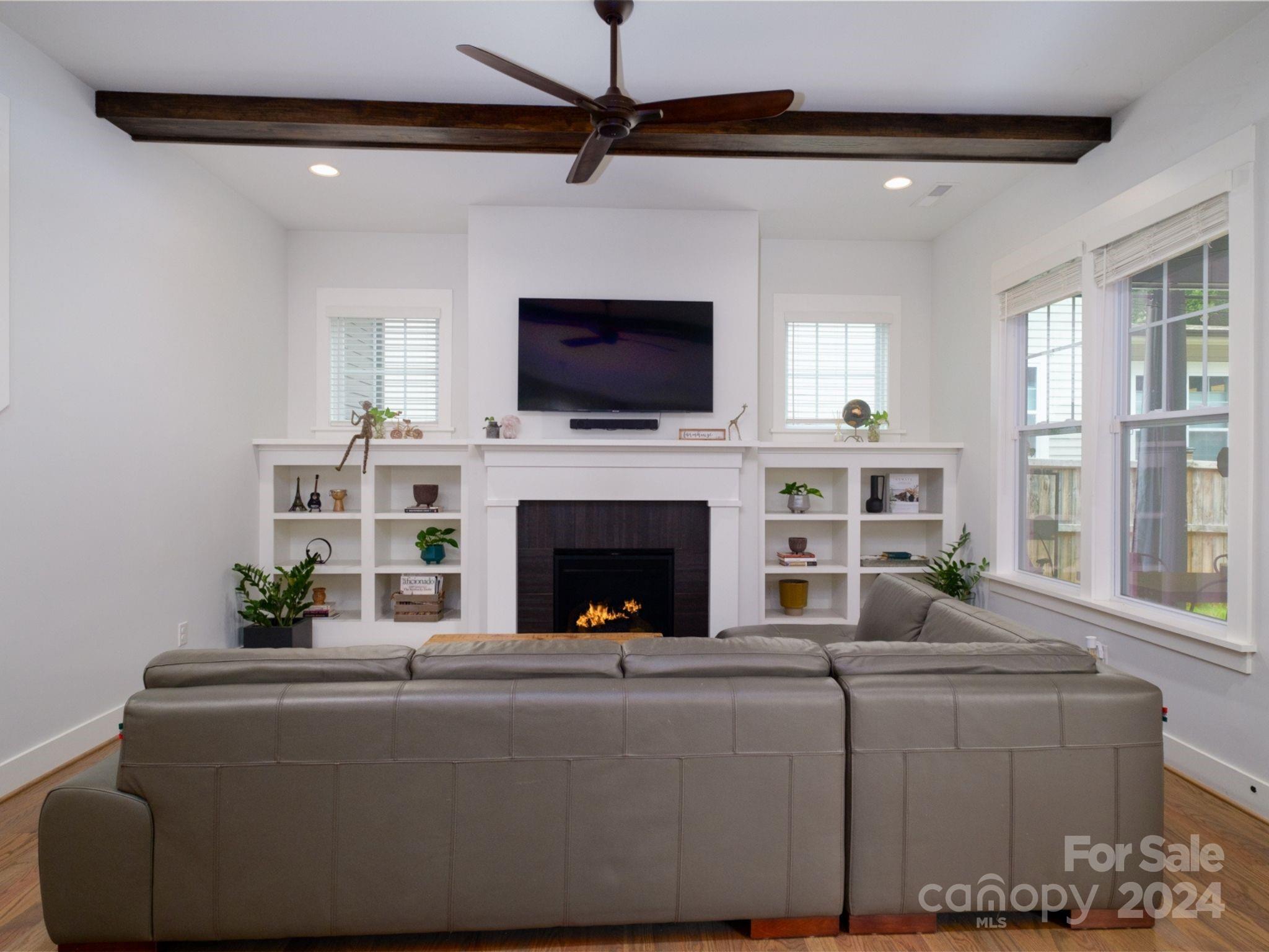 1410 Briar Creek Road Charlotte, NC 28205 - Photo 12 of 42 a living room with furniture a flat screen tv and a fireplace