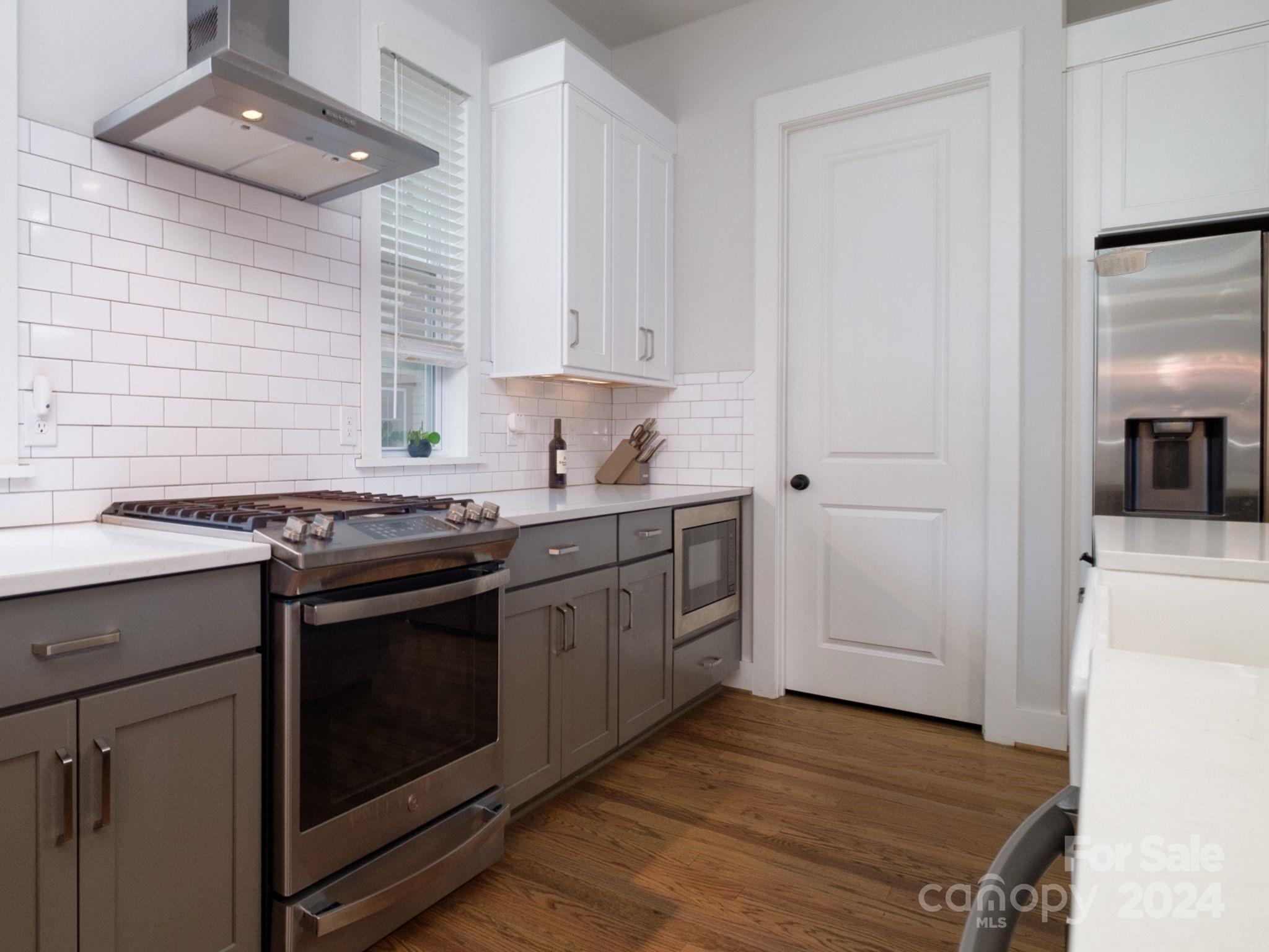 1410 Briar Creek Road Charlotte, NC 28205 - Photo 16 of 42 a kitchen with a stove cabinets and wooden floor