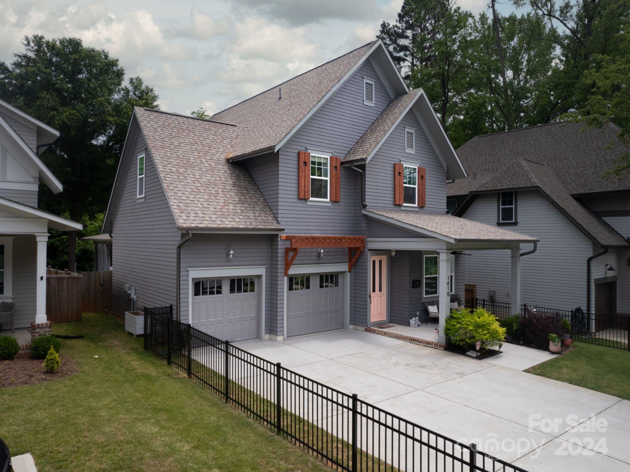 1410 Briar Creek Road Charlotte, NC 28205 - Photo 2 of 42 a view of a white house with large windows and a small yard