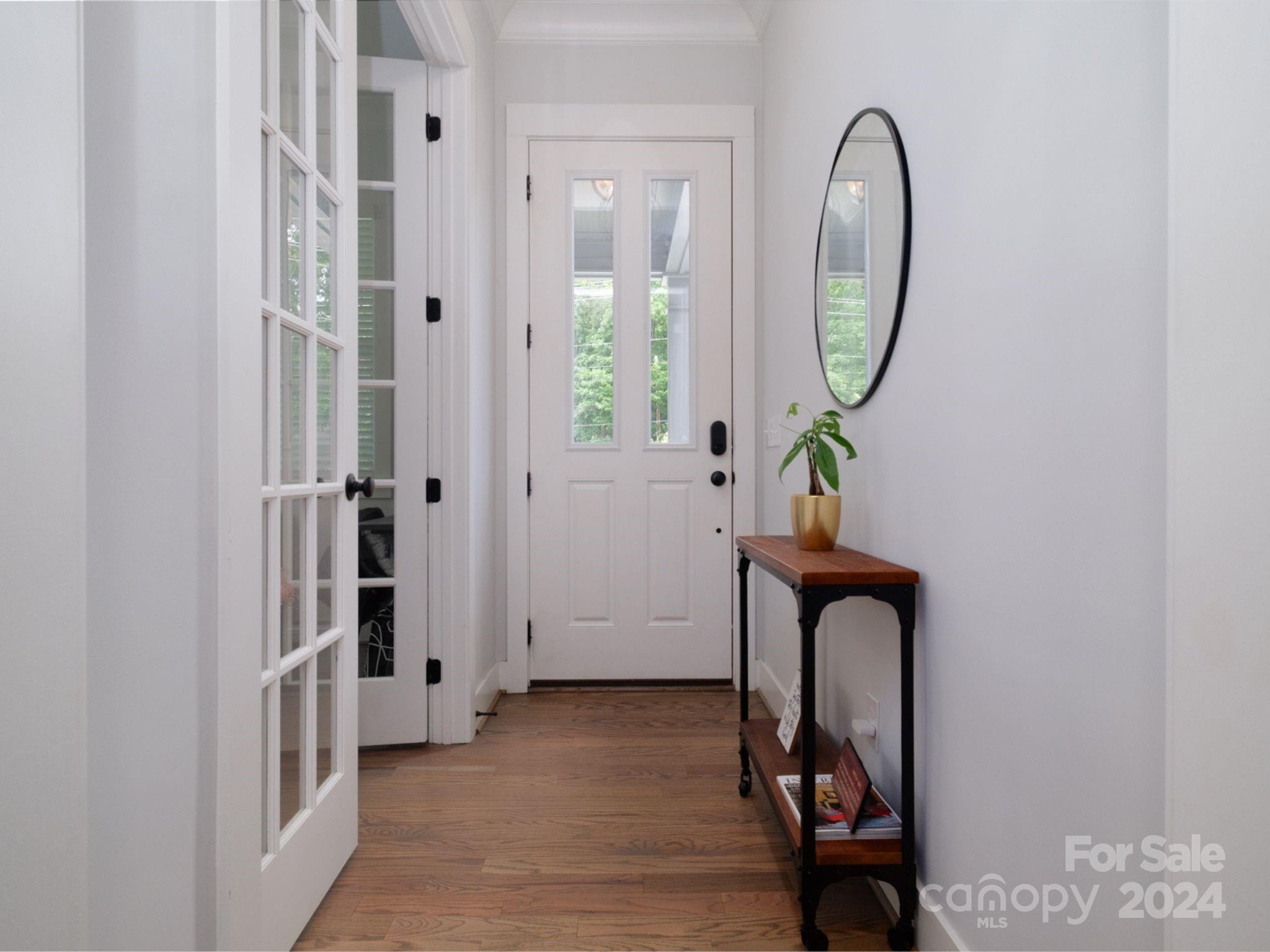1410 Briar Creek Road Charlotte, NC 28205 - Photo 10 of 42 an entryway to room with wooden floor mirror and windows