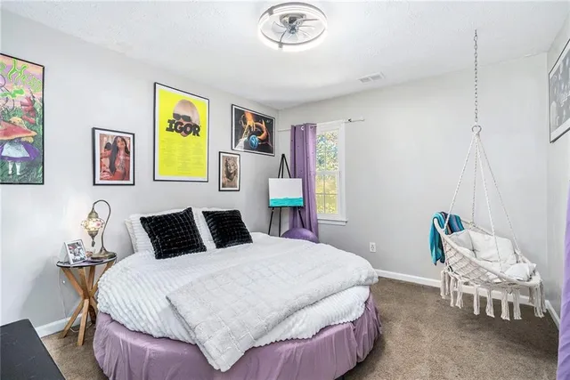 a bedroom with a bed and painting on the wall