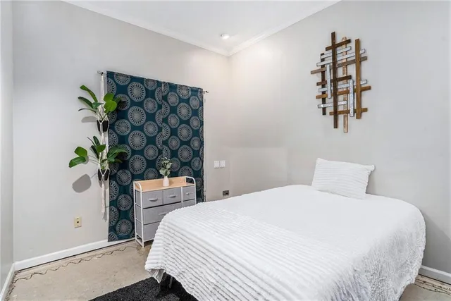 a bedroom with a bed and a potted plant