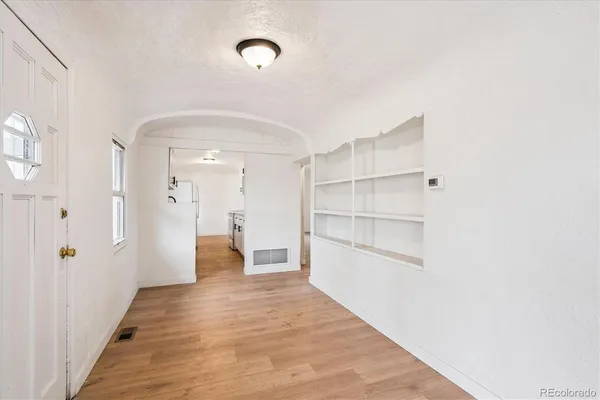 a view of a hallway with wooden floor and closet