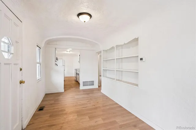 a view of a hallway with wooden floor and closet