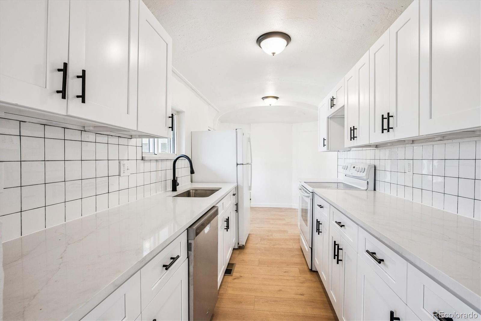 2110 Eagle Circle Aurora, CO 80011 - Photo 6 of 8 a kitchen with counter top space cabinets and stainless steel appliances