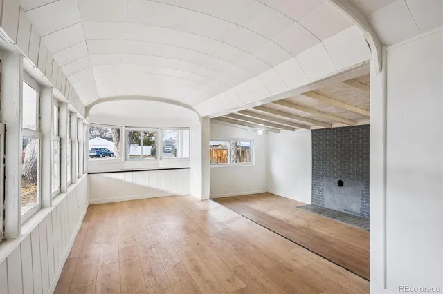 a view of a big room with wooden floor and windows
