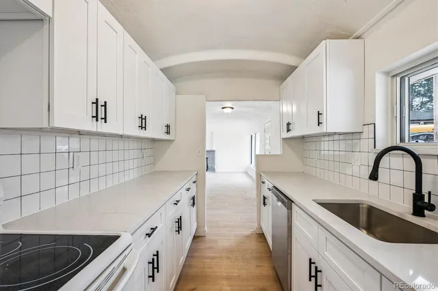 a kitchen with stainless steel appliances a sink stove and cabinets