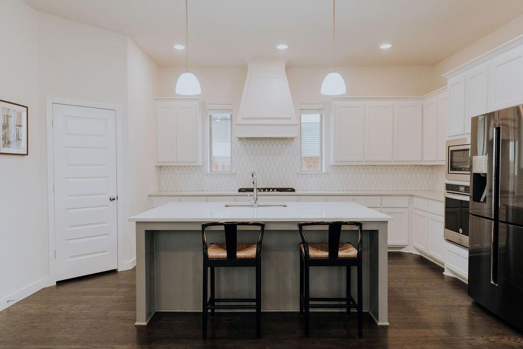 989 Sprangletop Street Allen, TX 75013 - Photo 3 of 20 a kitchen with a table chairs refrigerator and microwave