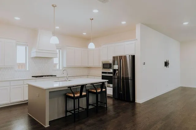 a kitchen with a table chairs refrigerator and microwave