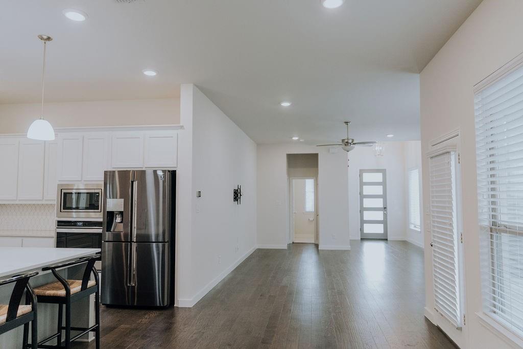 989 Sprangletop Street Allen, TX 75013 - Photo 6 of 20 a view of a kitchen with a refrigerator wooden floor and a window