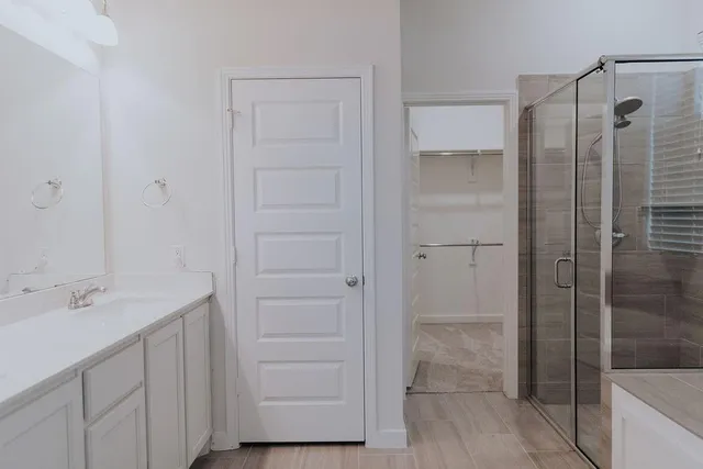 a bathroom with a shower sink and mirror