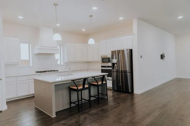a kitchen with a table chairs refrigerator and microwave