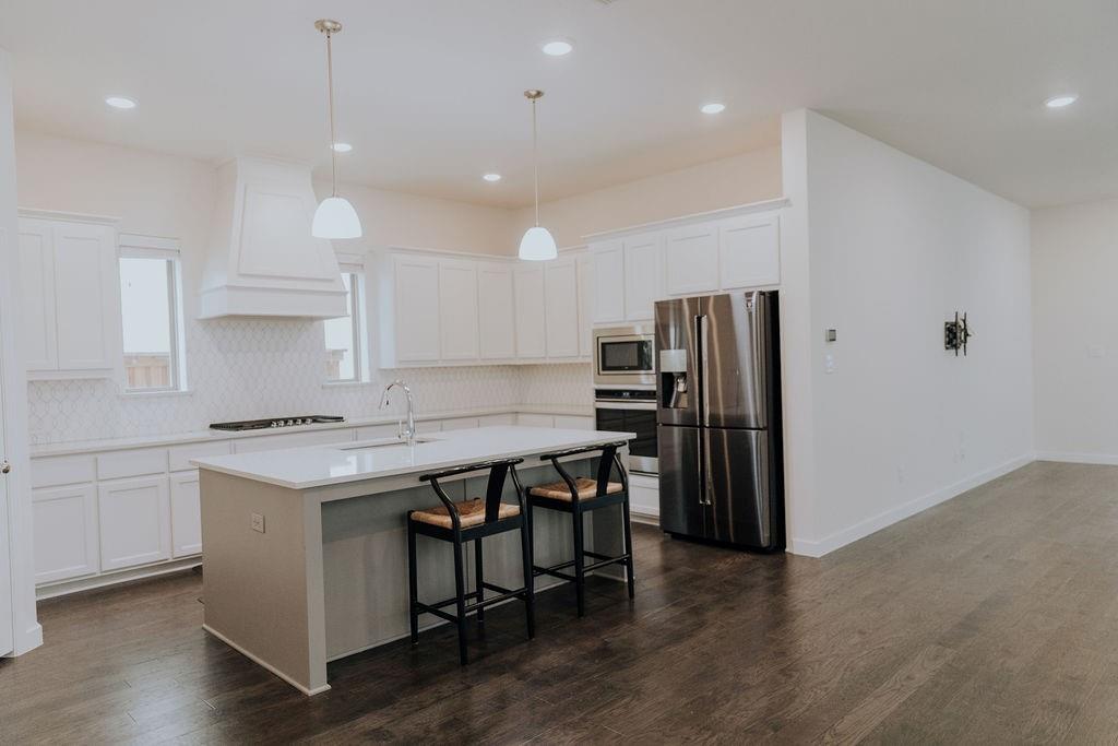 989 Sprangletop Street Allen, TX 75013 - Photo 10 of 20 a kitchen with a table chairs refrigerator and microwave