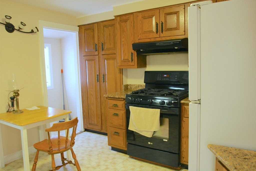 126 Russell Road Newton, MA 02465 - Photo 4 of 27 a kitchen with stainless steel appliances granite countertop a stove a refrigerator and a microwave