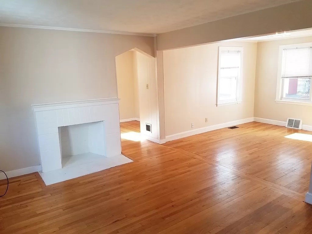 126 Russell Road Newton, MA 02465 - Photo 9 of 27 an empty room with wooden floor and windows