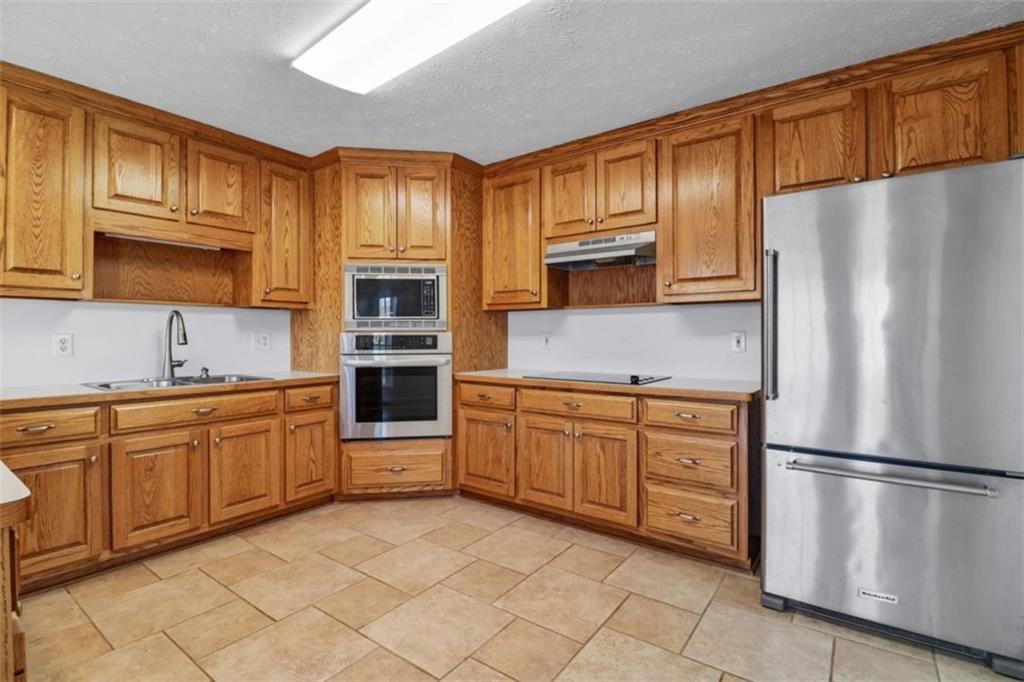 1828 4 Mile Church Road Ball Ground, GA 30107 - Photo 13 of 51 a kitchen with stainless steel appliances granite countertop a refrigerator sink and cabinets