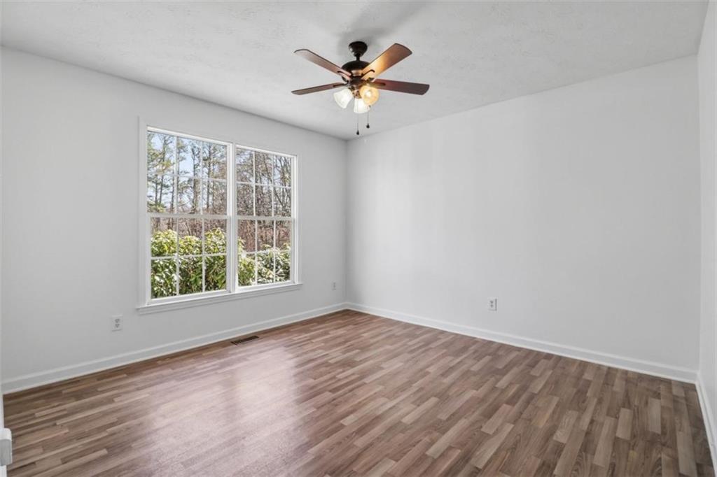 1828 4 Mile Church Road Ball Ground, GA 30107 - Photo 17 of 51 an empty room with wooden floor and windows